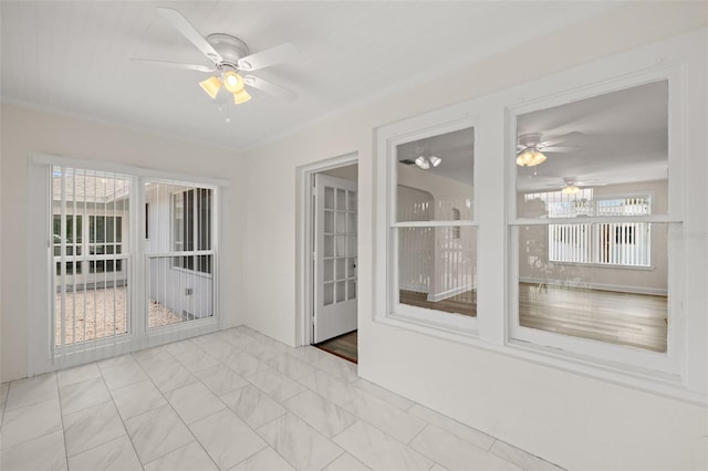 unfurnished sunroom with a wealth of natural light and ceiling fan