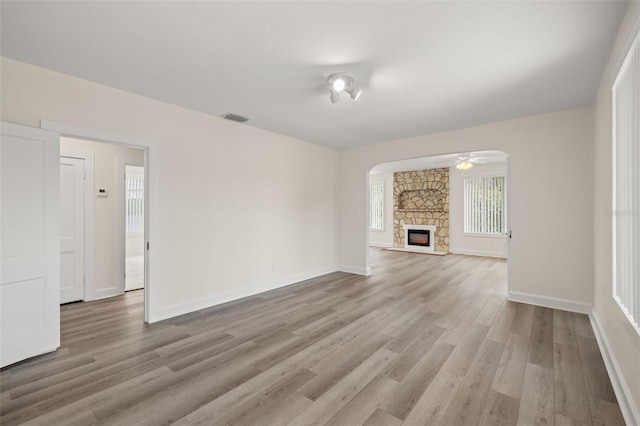 unfurnished living room featuring hardwood / wood-style flooring, a fireplace, and ceiling fan