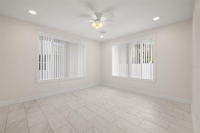 tiled empty room featuring ceiling fan