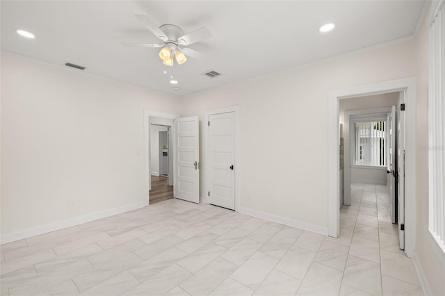 tiled spare room with ceiling fan