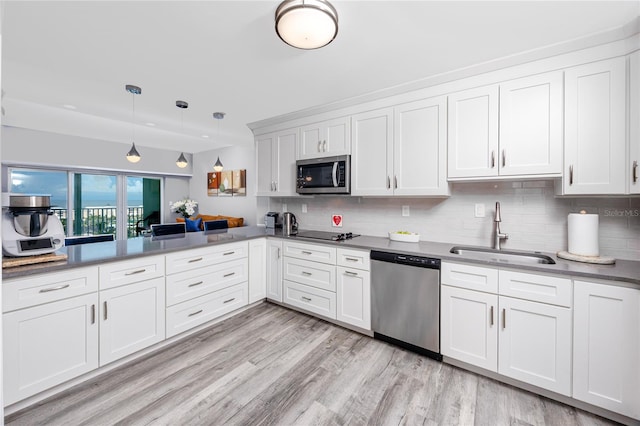 kitchen featuring decorative backsplash, light hardwood / wood-style flooring, appliances with stainless steel finishes, and sink