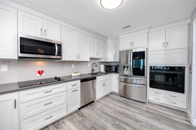 kitchen featuring black appliances, visible vents, white cabinets, and a sink