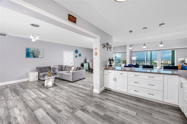 kitchen featuring decorative light fixtures, wood-type flooring, white cabinets, and a chandelier