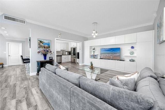 living area with ornamental molding, baseboards, visible vents, and light wood finished floors