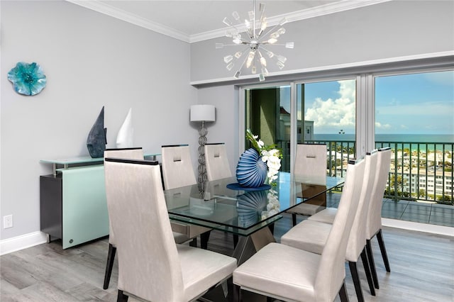 dining space featuring a water view, ornamental molding, a notable chandelier, and hardwood / wood-style floors