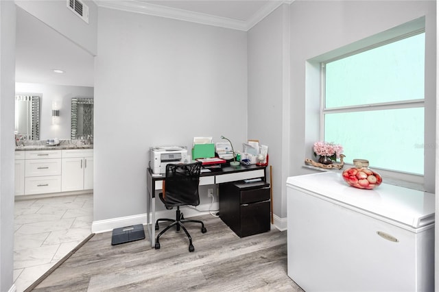 home office with light hardwood / wood-style flooring and ornamental molding