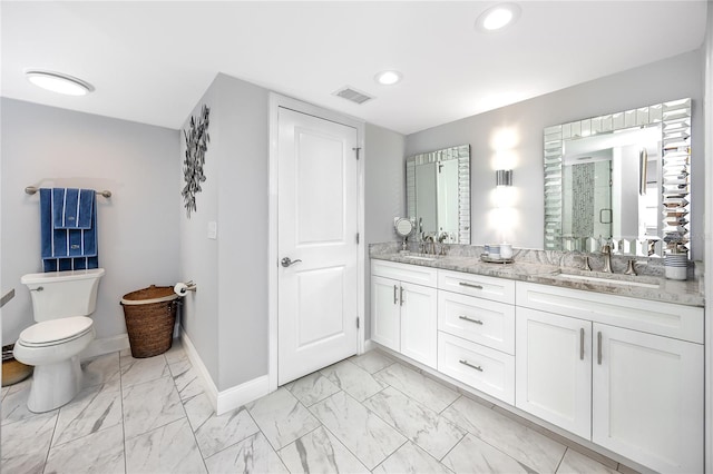 bathroom with dual vanity, toilet, and tile patterned flooring