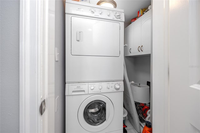 laundry area featuring cabinet space and stacked washing maching and dryer