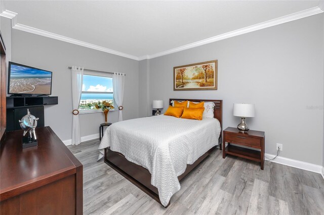 bedroom featuring ornamental molding and hardwood / wood-style floors