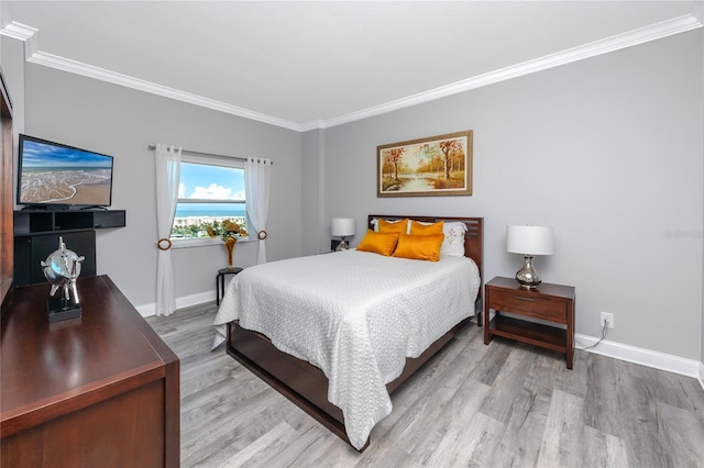 bedroom with crown molding, baseboards, and wood finished floors