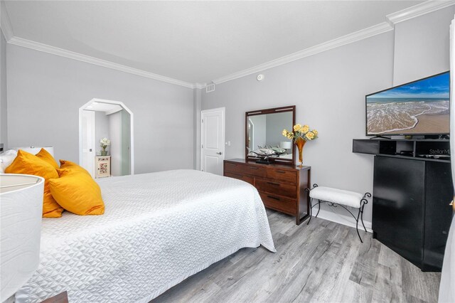 bedroom featuring ornamental molding and light hardwood / wood-style floors