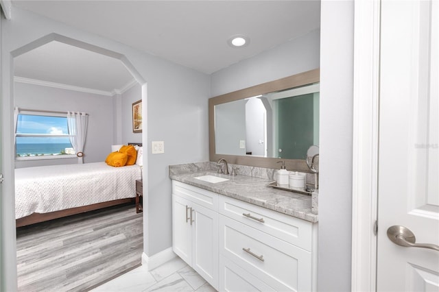 bathroom featuring ornamental molding, vanity, and wood-type flooring