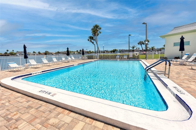 pool with fence and a patio