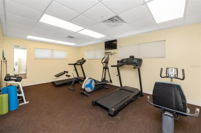 workout room featuring carpet and a paneled ceiling