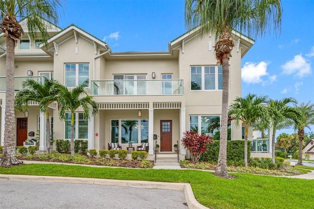 6 Hibiscus Ln, Belleair, FL 33756 - view of front of home with a balcony, stucco siding, covered porch, and a front yard