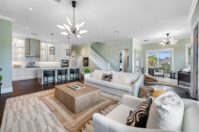 living room with an inviting chandelier, crown molding, and dark hardwood / wood-style floors