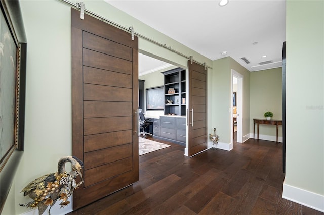 corridor with dark hardwood / wood-style flooring and a barn door