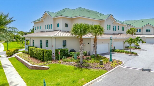 6 Hibiscus Ln, Belleair, FL 33756 - view of front facade with stucco siding, a garage, metal roof, a standing seam roof, and asphalt driveway