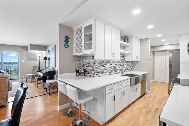 kitchen with appliances with stainless steel finishes, tasteful backsplash, white cabinetry, and sink