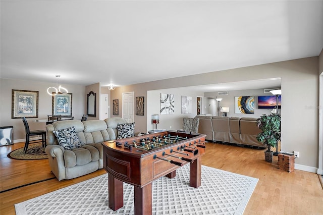 playroom with a notable chandelier and light wood-type flooring