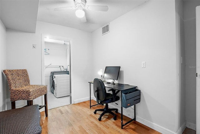 home office featuring ceiling fan, light hardwood / wood-style floors, and washer / dryer