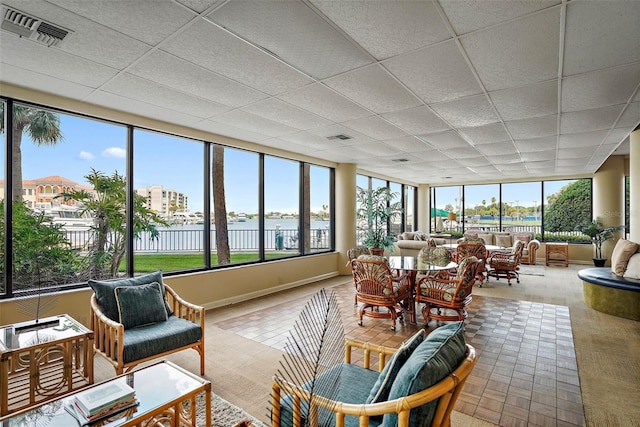 sunroom with a drop ceiling and a water view