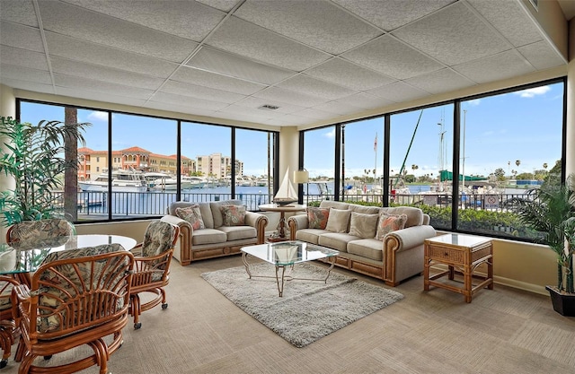 sunroom / solarium with a water view and a drop ceiling