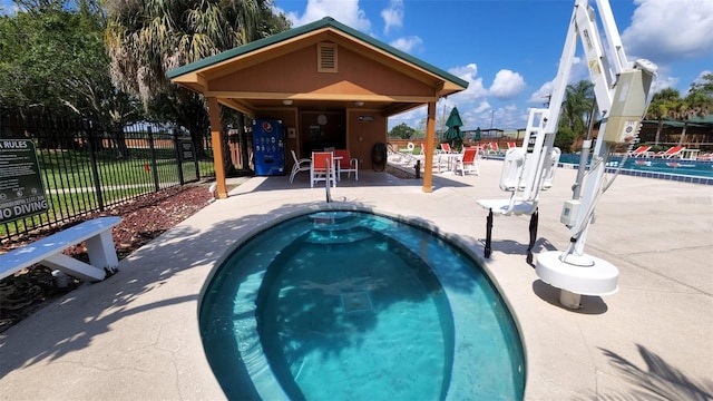 view of pool featuring a hot tub and a patio