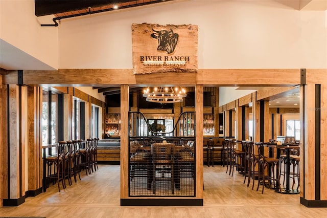 dining area with hardwood / wood-style flooring, vaulted ceiling with beams, and a chandelier