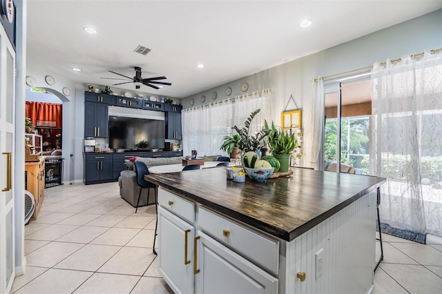 kitchen with blue cabinets, light tile patterned floors, white cabinets, and ceiling fan