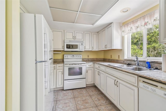 kitchen featuring white cabinetry, sink, white appliances, and light tile patterned floors