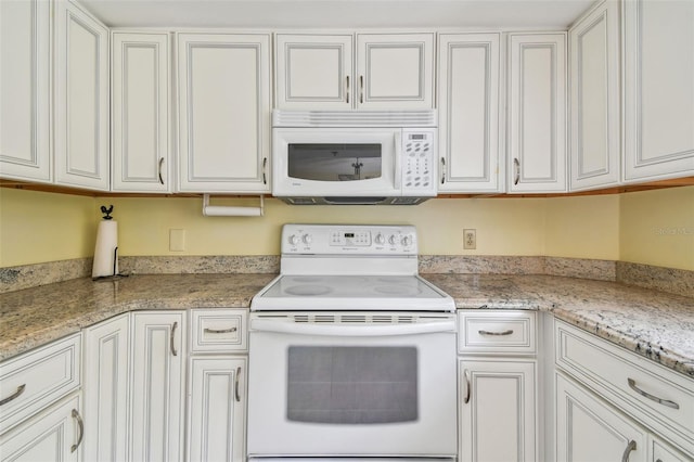 kitchen featuring light stone countertops, white cabinets, and white appliances