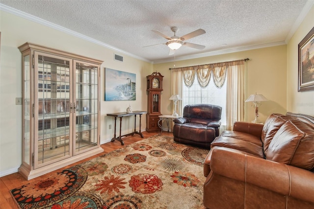 living room featuring crown molding, a textured ceiling, and light wood-type flooring