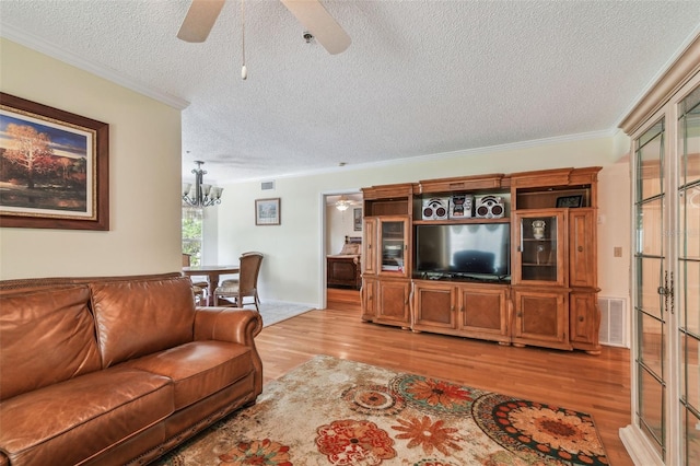 living room featuring ornamental molding, a textured ceiling, and light hardwood / wood-style flooring