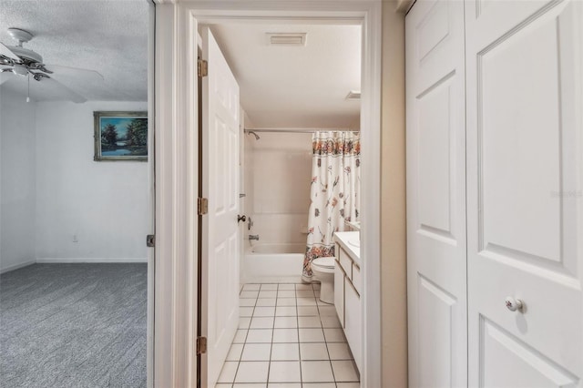 full bathroom with vanity, toilet, shower / bathtub combination with curtain, tile patterned floors, and a textured ceiling