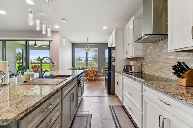 kitchen with hanging light fixtures, decorative backsplash, tile patterned floors, white cabinetry, and wall chimney exhaust hood