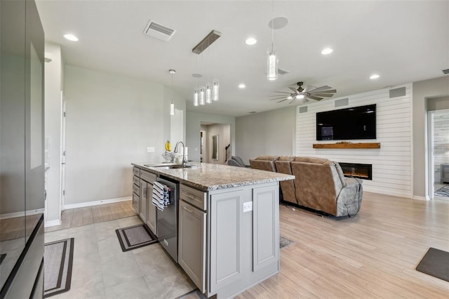 kitchen with a fireplace, sink, light hardwood / wood-style floors, an island with sink, and ceiling fan