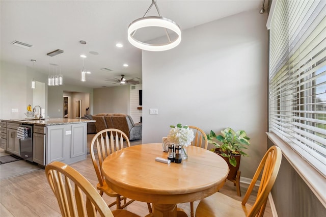 dining space with sink, light hardwood / wood-style flooring, and ceiling fan