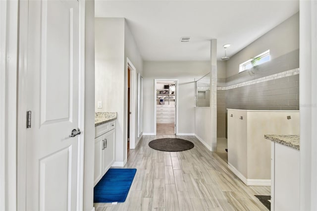 interior space with vanity and tiled shower