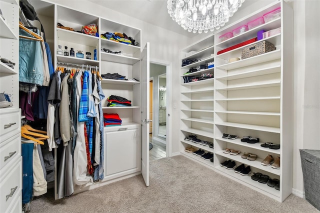 walk in closet featuring an inviting chandelier and light colored carpet