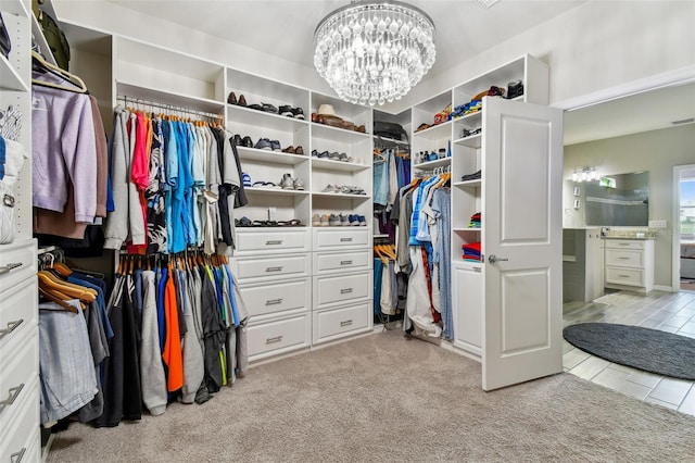 spacious closet featuring an inviting chandelier and light colored carpet