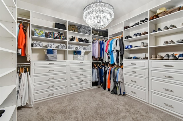 walk in closet with a chandelier and light carpet