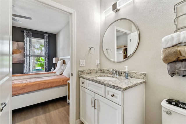 bathroom featuring vanity, ceiling fan, wood-type flooring, and toilet