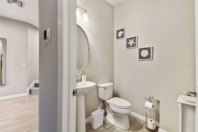 bathroom featuring hardwood / wood-style floors and toilet