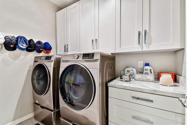 laundry area with washer and clothes dryer and cabinets