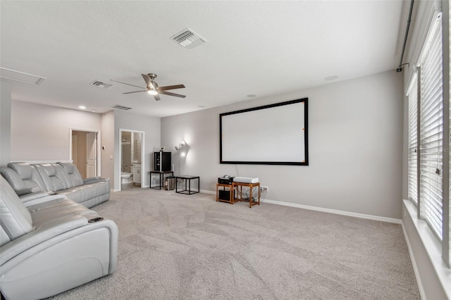 carpeted cinema room with ceiling fan