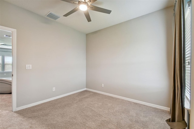 carpeted spare room featuring ceiling fan