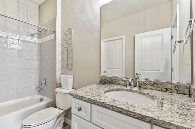 full bathroom with vanity, tiled shower / bath, and toilet