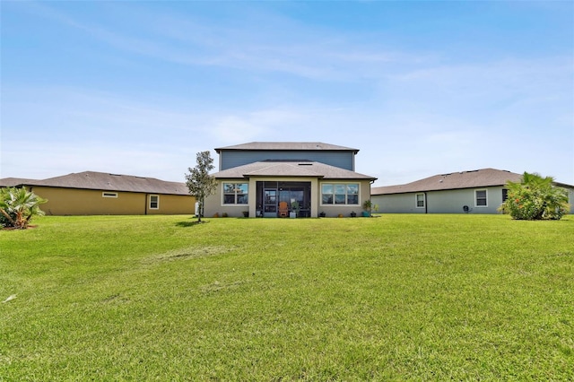 rear view of property featuring a lawn