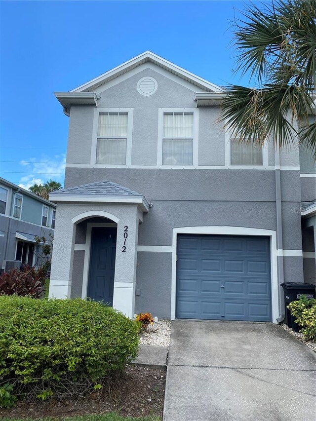 view of front facade featuring a garage, driveway, and stucco siding